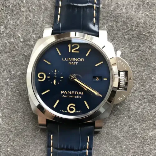 Luminor GMT dial lying flat on grey speckled fabric, alligator-pattern blue strap