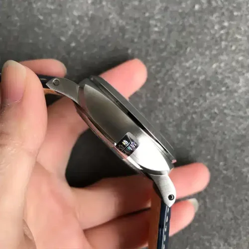 Left flank and lug seen edge-on, case held between the fingertips