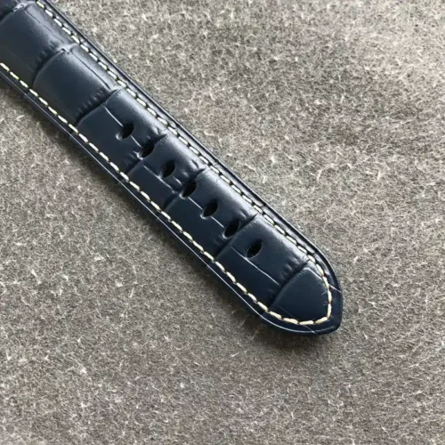 Navy embossed leather strap tail with cream stitching and holes