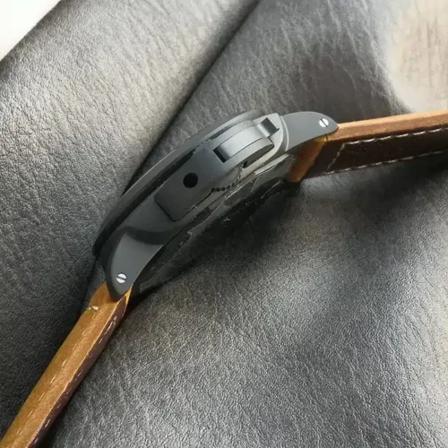 Crown guard lever and screws seen edge-on, tan strap behind
