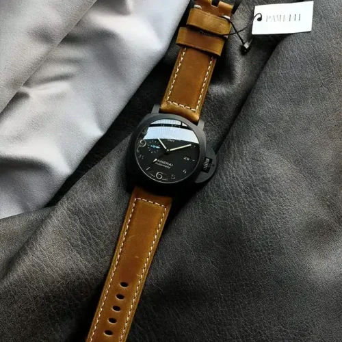 Whole watch on folded grey fabric, white tag hanging at the top