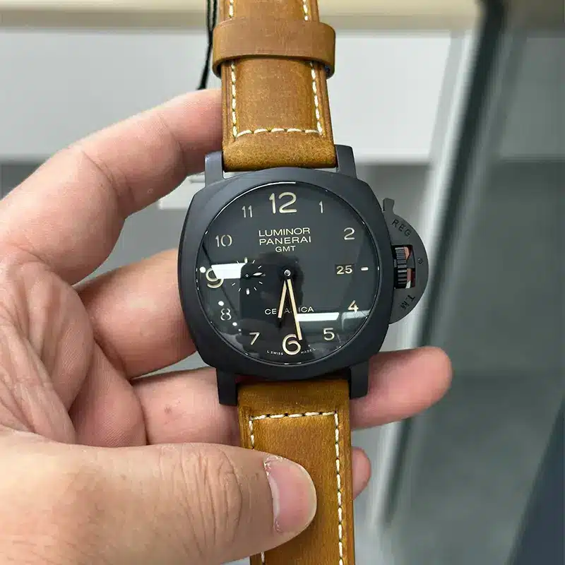 Held in the hand under shop lights, black dial with beige numerals