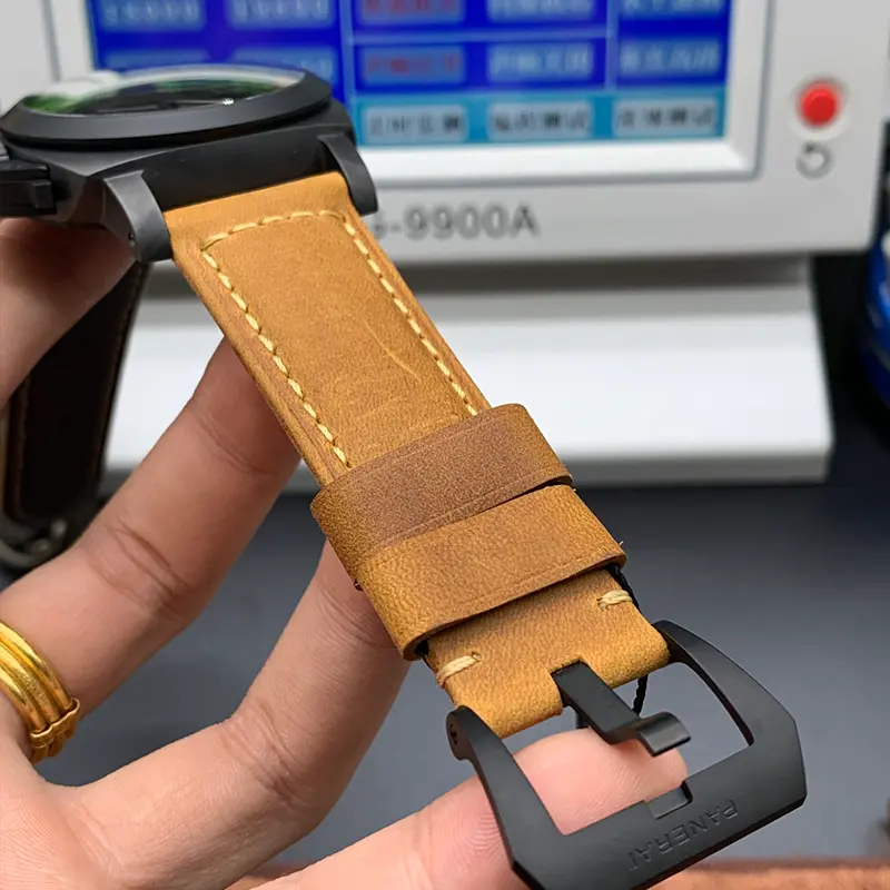 Tan strap keeper and black buckle seen from the underside