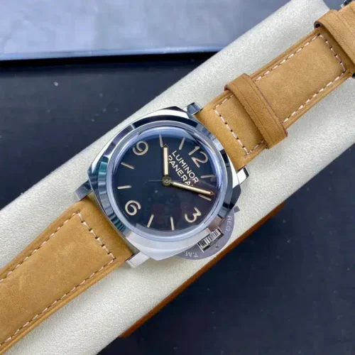 Watch resting on a cream stand, tan strap wrapped around it
