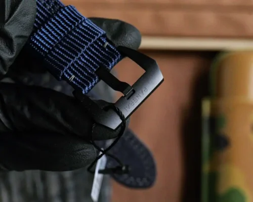 Matte black buckle signed Panerai on a woven blue strap