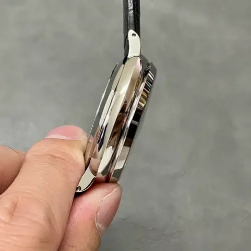 Thin left edge of the case pinched between two fingers, lugs polished