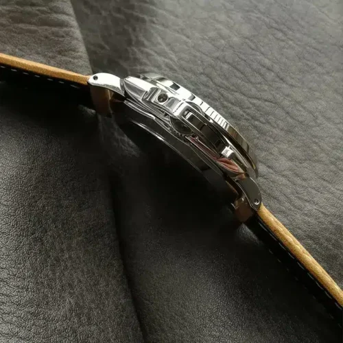 Crown guard side in profile, tan strap running off at both ends