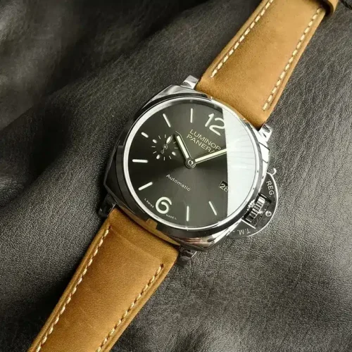 Glare across the anthracite dial, beige numerals at top and bottom