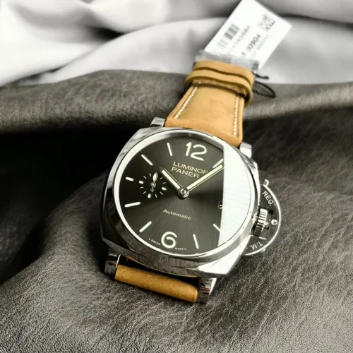 Grey dial facing up from a fold of fabric, barcode tag behind