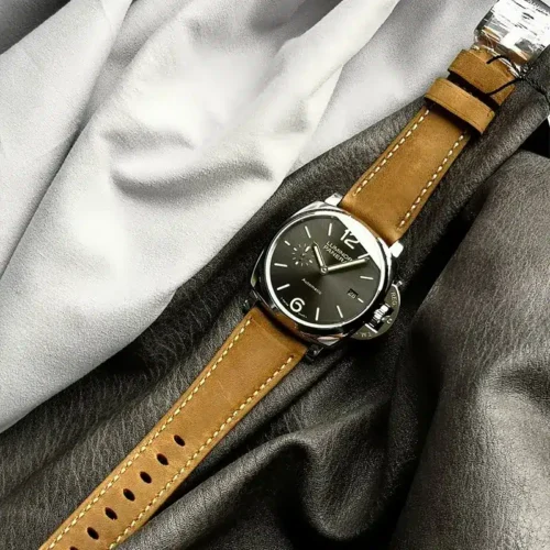 Full length of the tan strap with its holes, watch on dark grey fabric