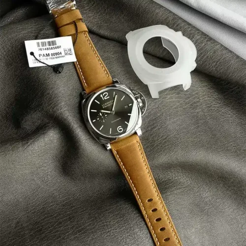 Tan strap and tag on grey cloth, clear plastic case guard beside it