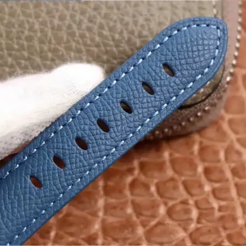 Blue grained strap end with light blue stitching and holes
