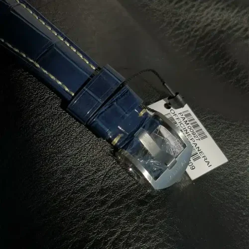 Polished buckle in film, white barcode tag on the navy strap