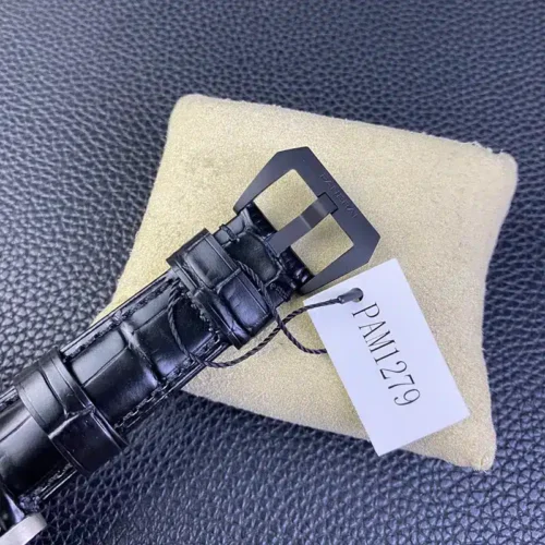 Black pin buckle threaded through croc-grain leather, reference tag hanging off