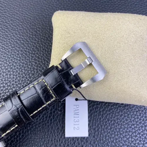 Brushed buckle above a paper tag on black croc leather with white stitching