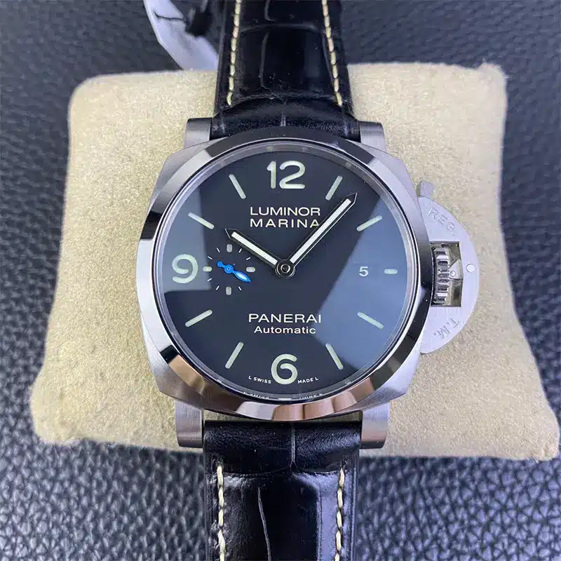 Black dial with date 5 on a cream pillow, white stitched strap above