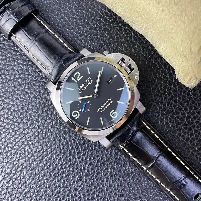 Whole watch on pebbled dark leather beside the pillow, date 5