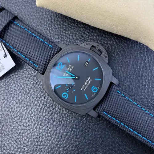 Whole watch on dark leather, tag at the left edge, blue stitched strap