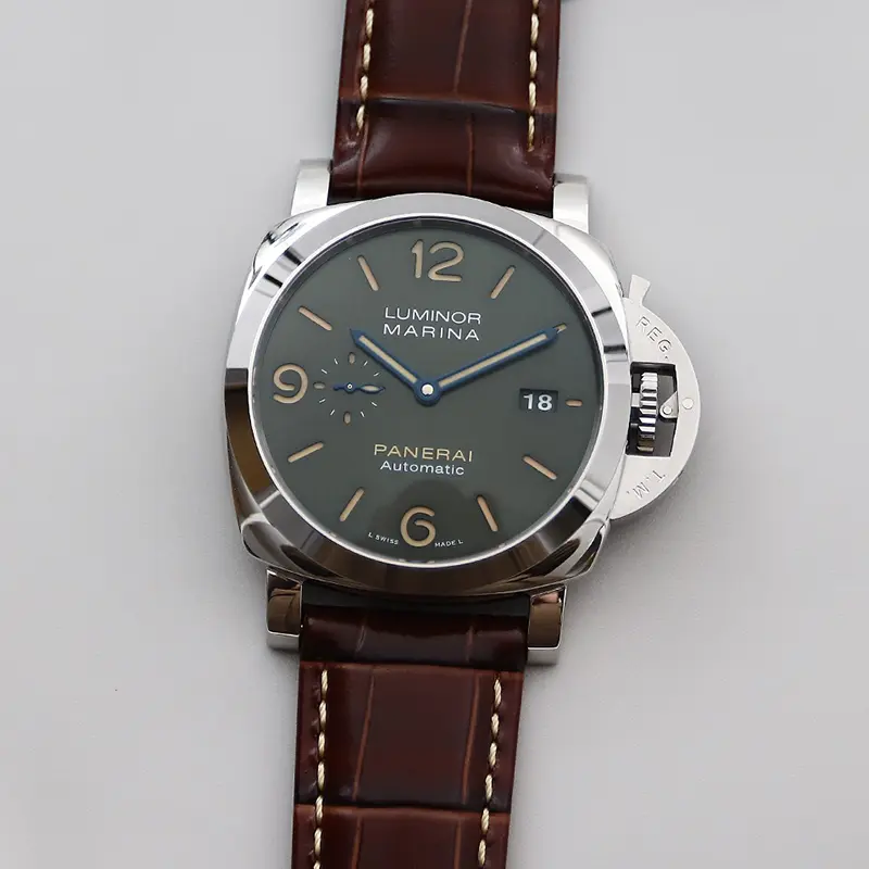 Straight-on photo of the green dial with beige numerals and blue hands
