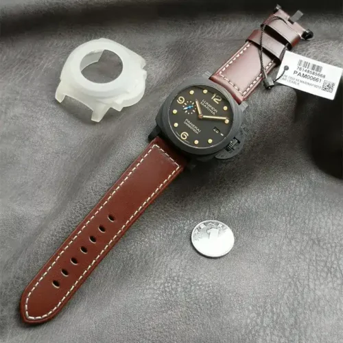 Luminor Marina PAM661 on grey cloth with a coin and clear case guard