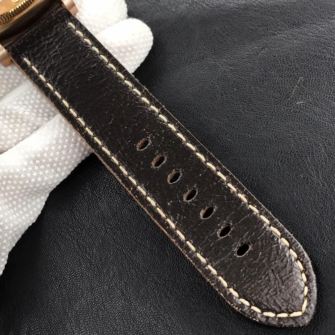 Distressed dark brown leather tail with cream stitching held in a glove