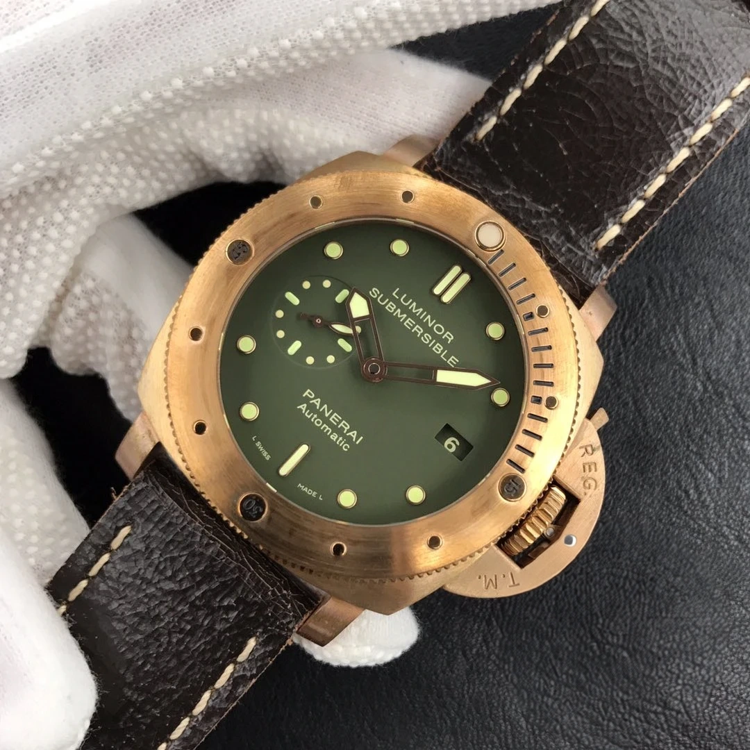 Olive dial rotated clockwise between gloved fingers, crown guard toward the bottom