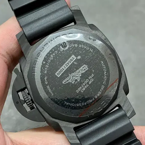 Dark back with a frogman motif and sticker 12, held in the palm