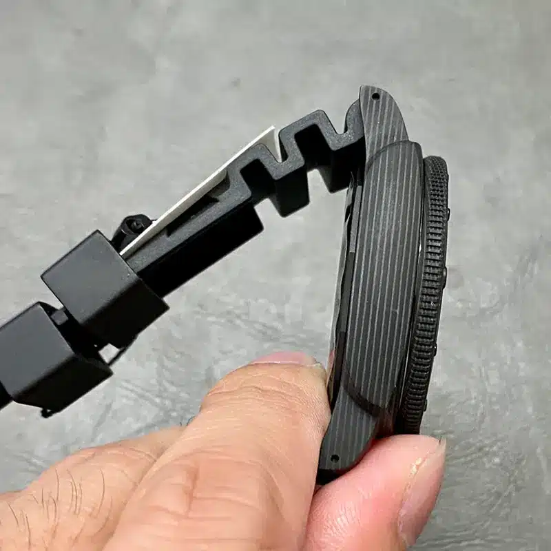 Marbled case and bezel edge held sideways between the fingers