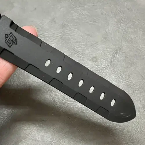 Tapered end of the black strap with punched holes and logo