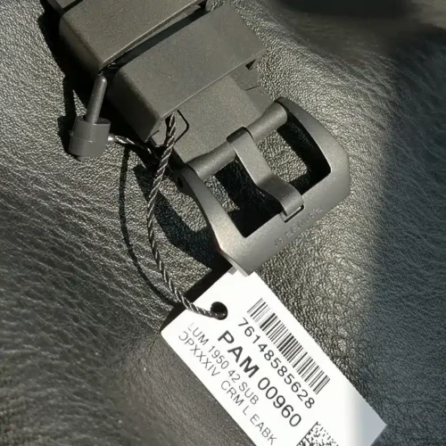 Black pin buckle and keeper, barcode tag hanging from the strap