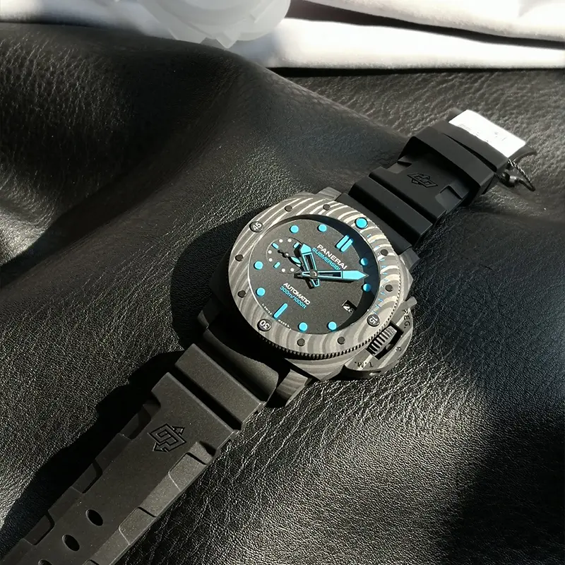 Watch lying on black leather with its rubber strap and hang tag