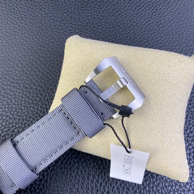 Brushed buckle on grey canvas, paper tag hanging on a black cord