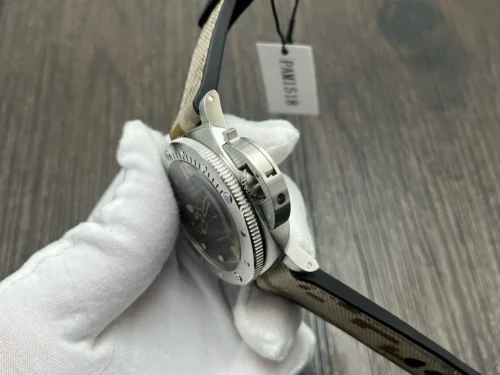 Crown guard side held in a white glove, paper tag hanging behind