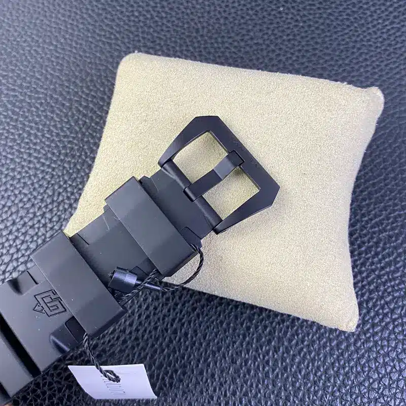 Rubber strap fastened with a black buckle, paper tag dangling below