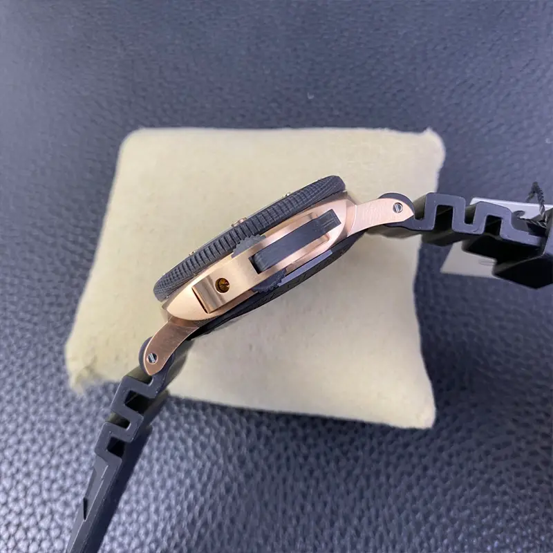 Crown side profile, gold tone guard bridge against the dark carbon bezel
