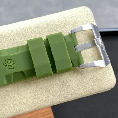 Brushed pin buckle closing the green rubber, embossed logo near the keepers