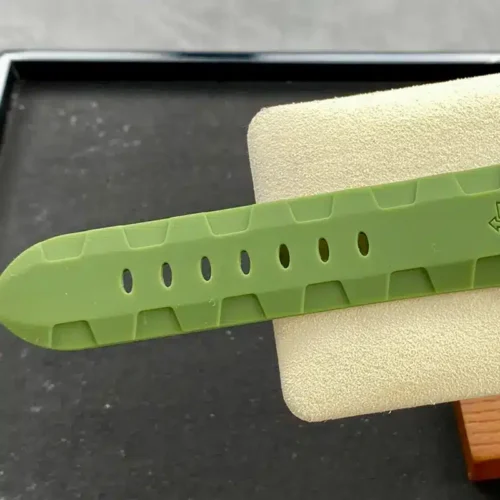 Green rubber strap end with a row of oval holes on the stand