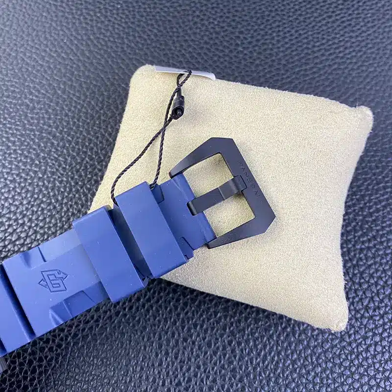Black brushed buckle closing the blue rubber, tag cord looped above
