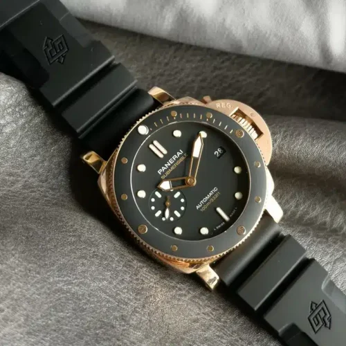Black bezel insert with gold tone markers, case resting on grey cloth