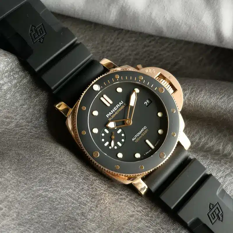 Black bezel insert with gold tone markers, case resting on grey cloth