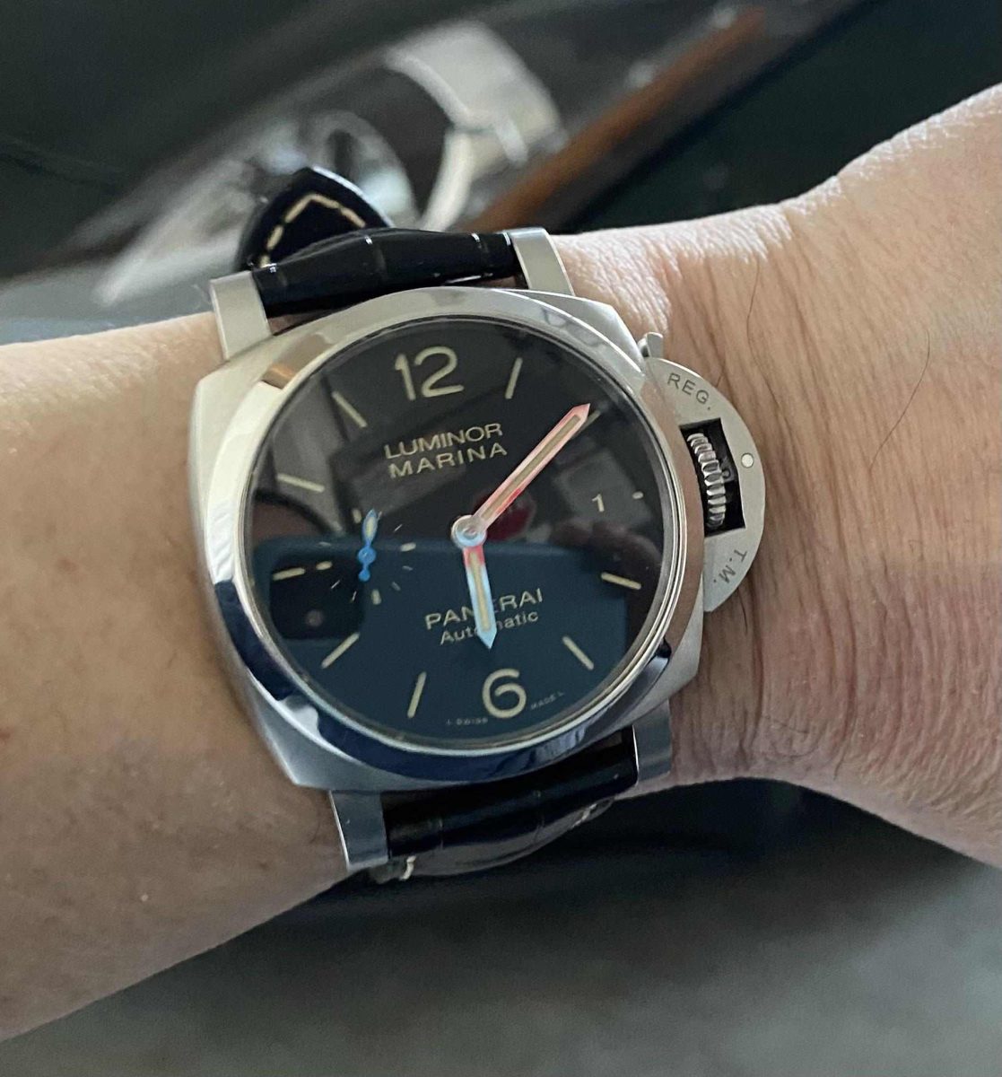 Steel Panerai Luminor Marina on the wrist, black dial with blue small seconds hand